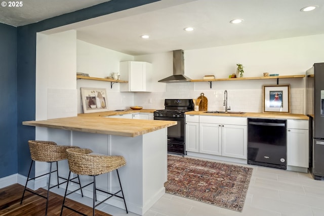 421 SE 141st Ave, Portland, OR 97233 - kitchen featuring butcher block countertops, black appliances, wall chimney exhaust hood, open shelves, and a sink