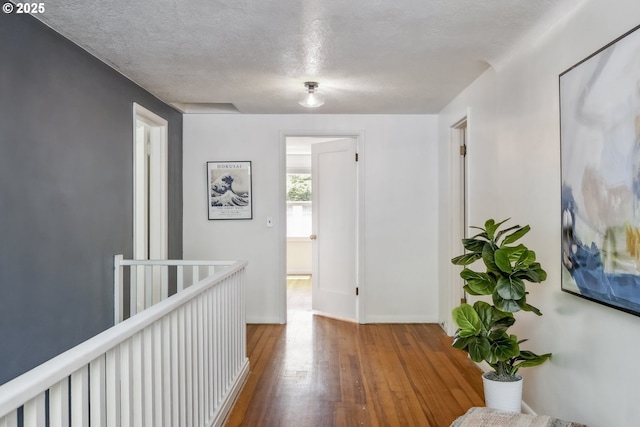 421 SE 141st Ave, Portland, OR 97233 - hallway featuring wood-type flooring, a textured ceiling, and an upstairs landing