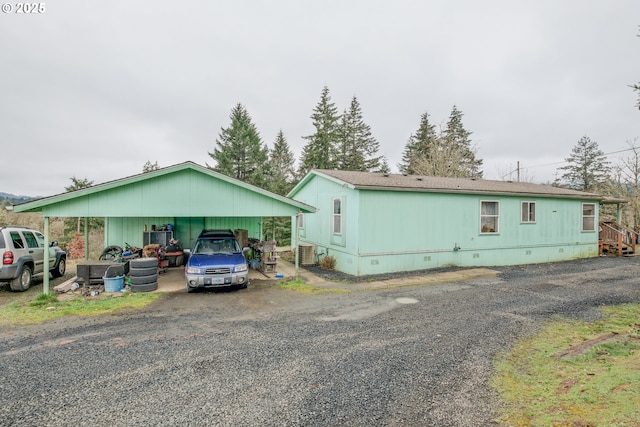 view of front of house with crawl space, a carport, cooling unit, and driveway