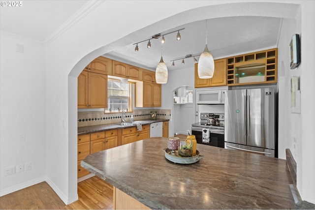 521 21st Ave, Longview, WA 98632 - kitchen featuring stainless steel appliances, dark countertops, a sink, arched walkways, and tasteful backsplash