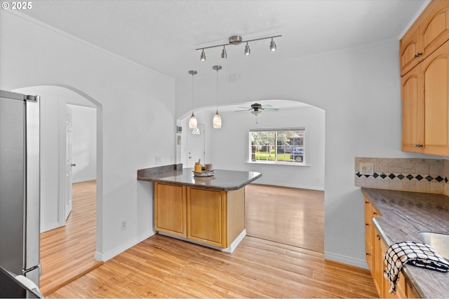 521 21st Ave, Longview, WA 98632 - kitchen featuring arched walkways, a peninsula, light wood-style flooring, a ceiling fan, and stainless steel refrigerator