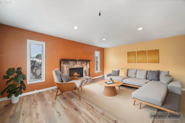 living area featuring recessed lighting, baseboards, wood finished floors, and a fireplace