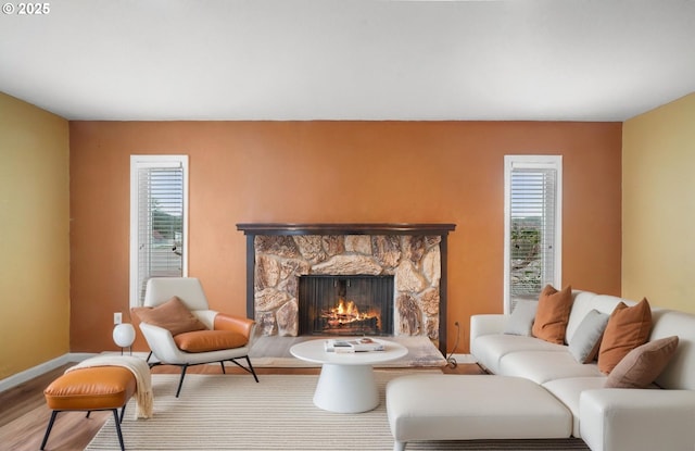 living room featuring a fireplace, wood finished floors, and baseboards