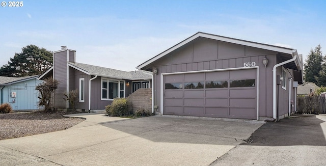 ranch-style house featuring concrete driveway, a chimney, a garage, and fence