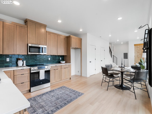 kitchen featuring backsplash, recessed lighting, appliances with stainless steel finishes, and light wood-style floors