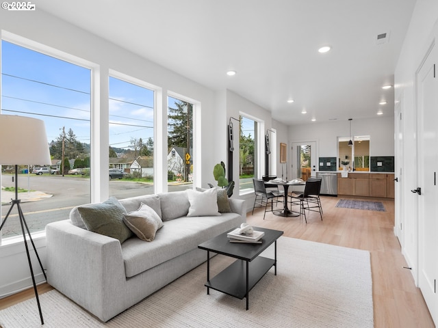 living area featuring light wood-style flooring, visible vents, and recessed lighting