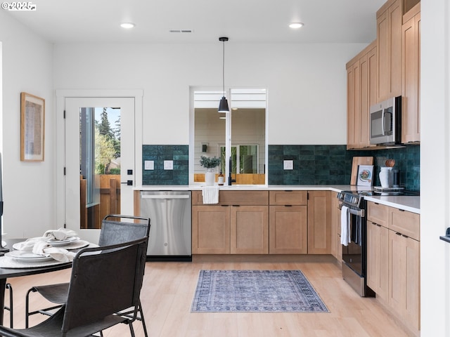 kitchen featuring light wood-type flooring, light brown cabinets, light countertops, visible vents, and stainless steel appliances