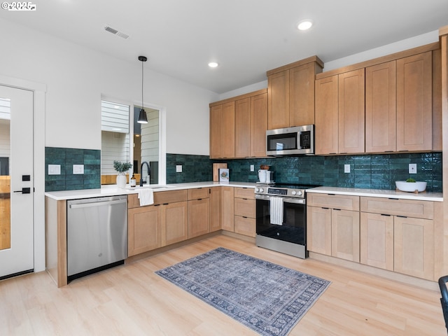 kitchen with visible vents, light countertops, stainless steel appliances, light wood finished floors, and light brown cabinets