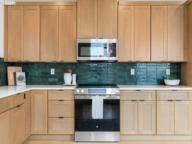 kitchen with light countertops, light brown cabinets, backsplash, and stainless steel appliances