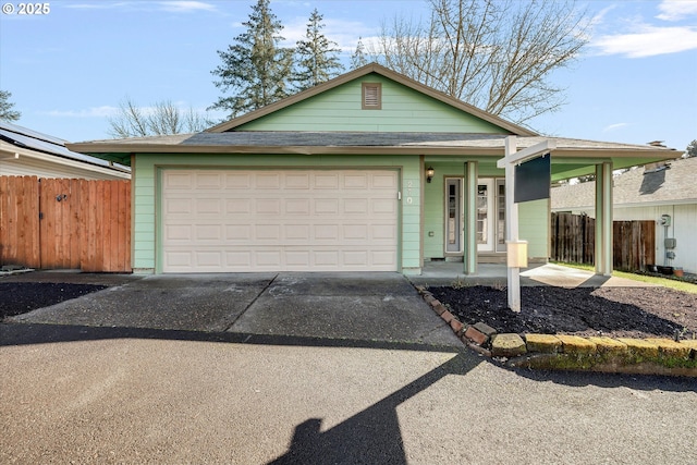 view of front of home with concrete driveway, an attached garage, and fence