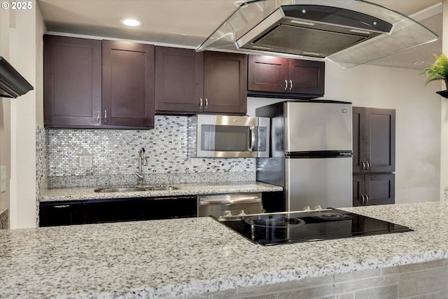 kitchen featuring a sink, under cabinet range hood, backsplash, appliances with stainless steel finishes, and light stone countertops