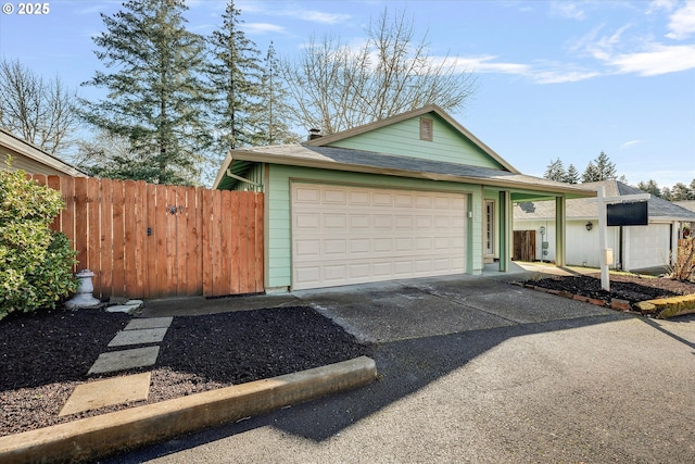 view of front of home with fence, driveway, and a shingled roof