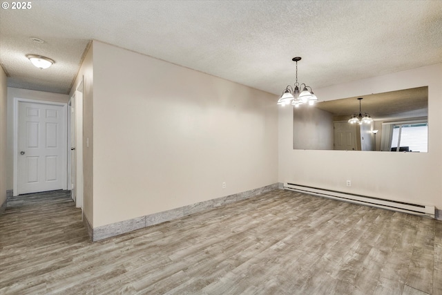 unfurnished room featuring baseboards, a chandelier, baseboard heating, wood finished floors, and a textured ceiling