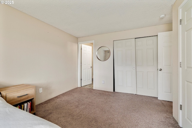 unfurnished bedroom with a closet, carpet floors, and a textured ceiling