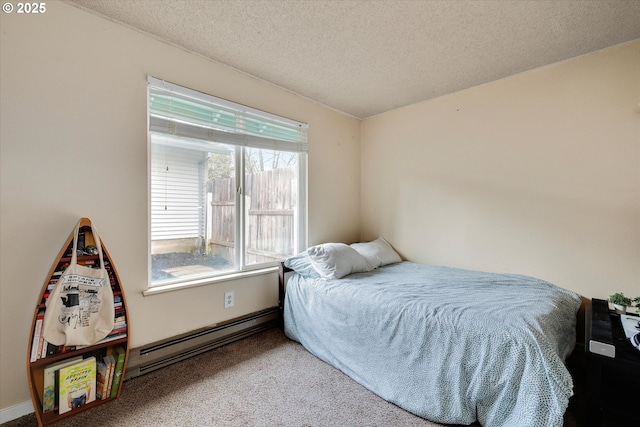 bedroom with baseboard heating, a textured ceiling, and carpet