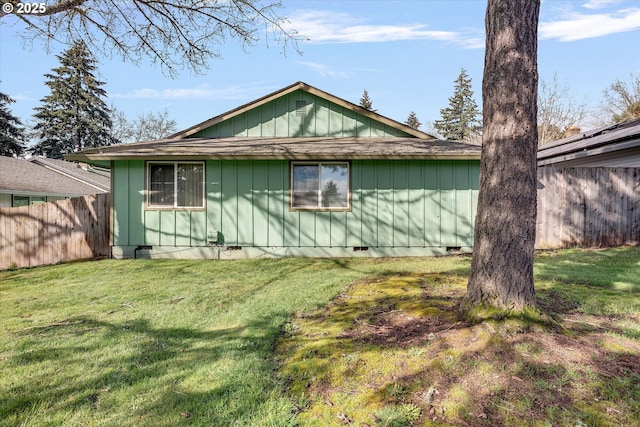 view of property exterior featuring crawl space, a lawn, and fence