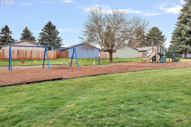 communal playground featuring a yard and fence