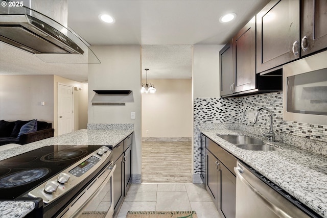 kitchen featuring a sink, stainless steel appliances, light stone counters, and backsplash