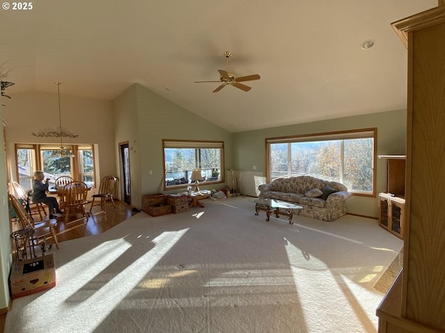 unfurnished living room with high vaulted ceiling, carpet, and a ceiling fan