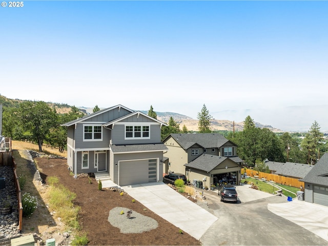 1405 Gordon Ct, The Dalles, OR 97058 - view of front of house with board and batten siding, driveway, an attached garage, and a mountain view
