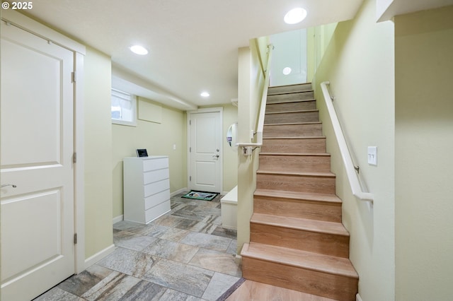 stairway featuring recessed lighting, baseboards, and stone finish floor