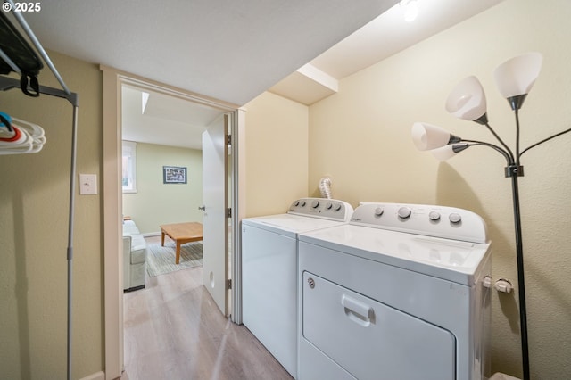 laundry area featuring washing machine and clothes dryer, laundry area, and light wood-style floors