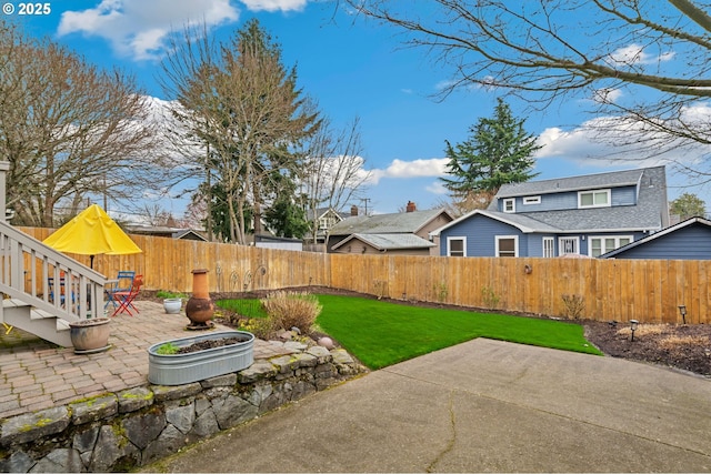 view of yard featuring a patio area, a residential view, and a fenced backyard