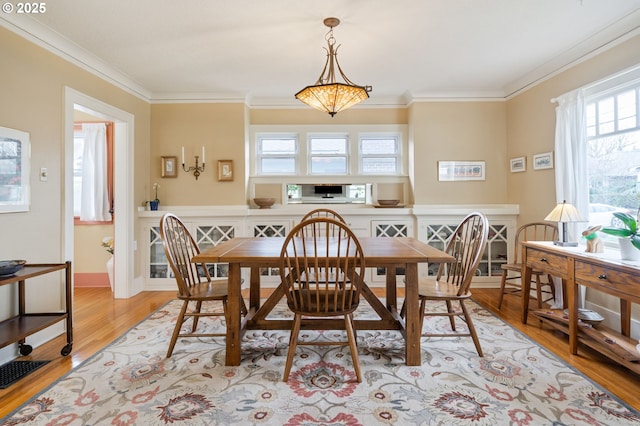 dining room with crown molding, light wood-style flooring, baseboards, and visible vents