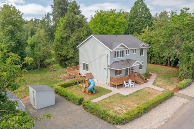 21795 SE Grand Island Loop, Dayton, OR 97114 - rear view of property with a storage unit, a yard, a deck, a playground, and a wooded view