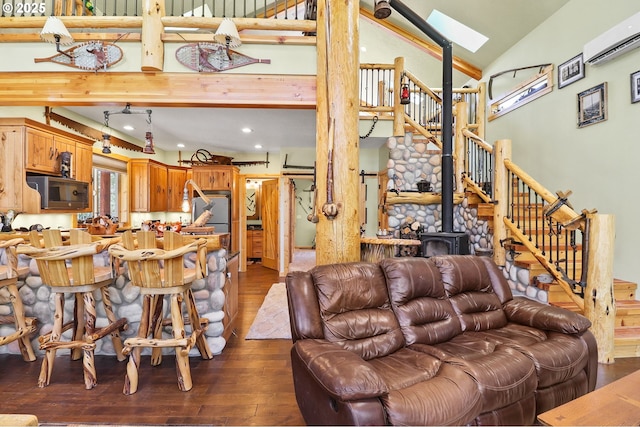 123604 Muttonchop St, Crescent Lake, OR 97733 - living room with dark wood finished floors, a wall mounted air conditioner, a wood stove, stairway, and high vaulted ceiling
