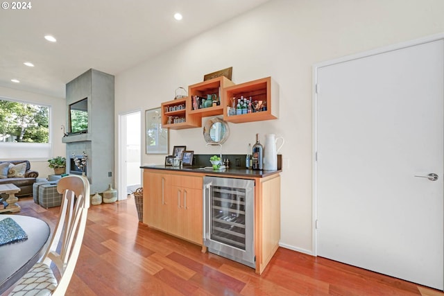 bar with wine cooler, sink, and light hardwood / wood-style floors