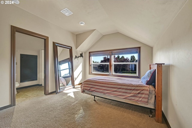 carpeted bedroom featuring lofted ceiling and ensuite bathroom