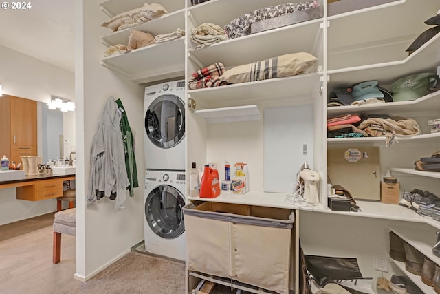 clothes washing area with stacked washer and clothes dryer and light hardwood / wood-style floors