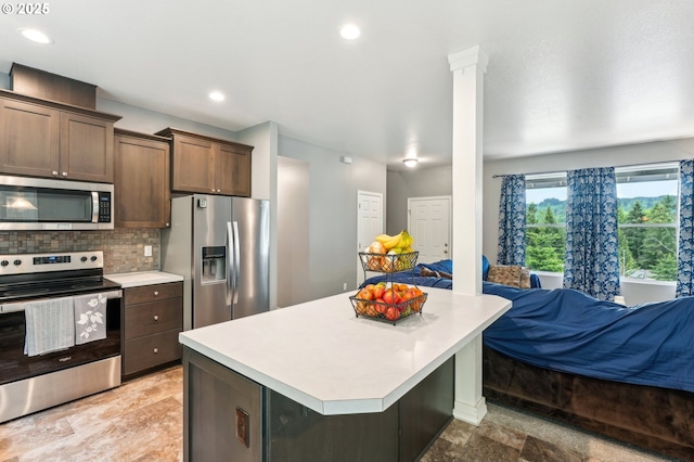 250 Sylvan Way, Longview, WA 98632 - kitchen featuring stainless steel appliances, open floor plan, light countertops, decorative backsplash, and a kitchen island