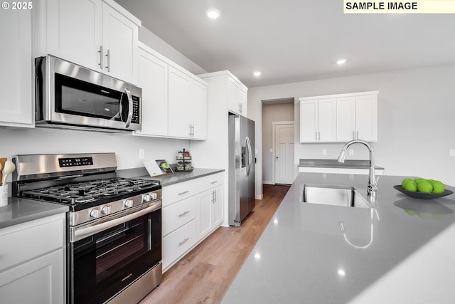 834 Misty Ln, Forest Grove, OR 97116 - kitchen with stainless steel appliances, a sink, recessed lighting, white cabinets, and light wood-type flooring