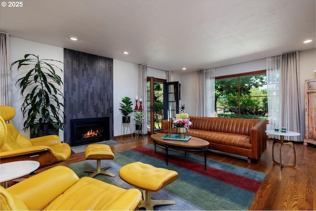 living area with recessed lighting, wood finished floors, and a fireplace