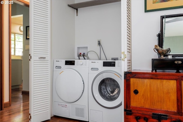 laundry room with laundry area, dark wood finished floors, and washer and clothes dryer