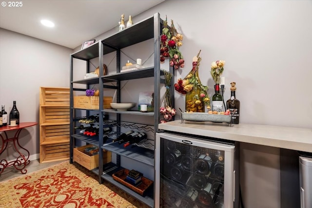 interior space featuring beverage cooler, baseboards, recessed lighting, and a bar