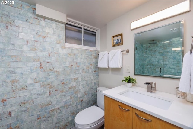 bathroom featuring toilet, a shower stall, and vanity