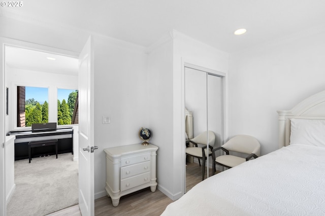 bedroom with baseboards, ornamental molding, wood finished floors, a closet, and recessed lighting