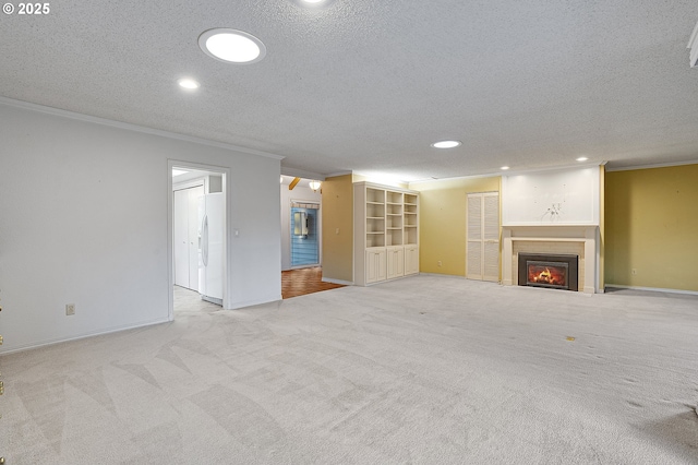 7785 SW Fairway Dr, Wilsonville, OR 97070 - unfurnished living room featuring a textured ceiling, crown molding, a glass covered fireplace, carpet flooring, and recessed lighting