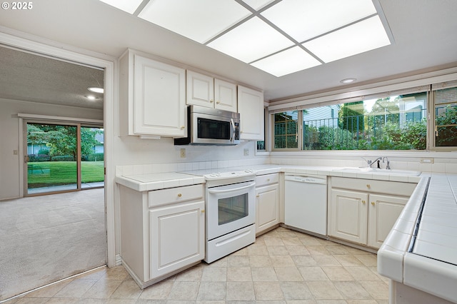 7785 SW Fairway Dr, Wilsonville, OR 97070 - kitchen with white appliances, tile counters, a sink, plenty of natural light, and recessed lighting