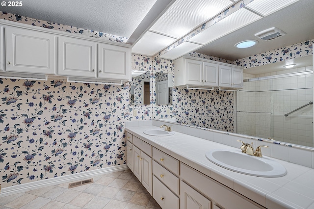 7785 SW Fairway Dr, Wilsonville, OR 97070 - full bath featuring wallpapered walls, baseboards, double vanity, a tile shower, and tile patterned flooring