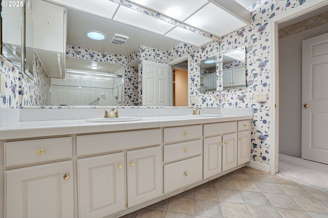 7785 SW Fairway Dr, Wilsonville, OR 97070 - bathroom with wallpapered walls, double vanity, tiled shower, baseboards, and tile patterned floors