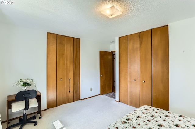 12330 SE Main St, Portland, OR 97233 - bedroom featuring two closets, a textured ceiling, and light carpet