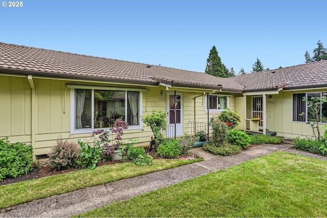 12330 SE Main St, Portland, OR 97233 - ranch-style home featuring board and batten siding, a front lawn, and a tiled roof