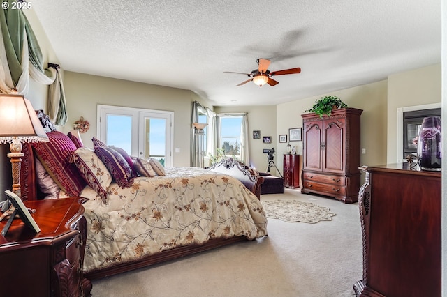 carpeted bedroom featuring access to outside, a textured ceiling, and ceiling fan