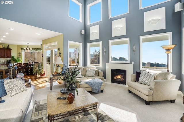 living room with an inviting chandelier, plenty of natural light, and a fireplace