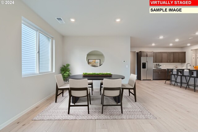 kitchen with sink, stainless steel appliances, and light hardwood / wood-style floors