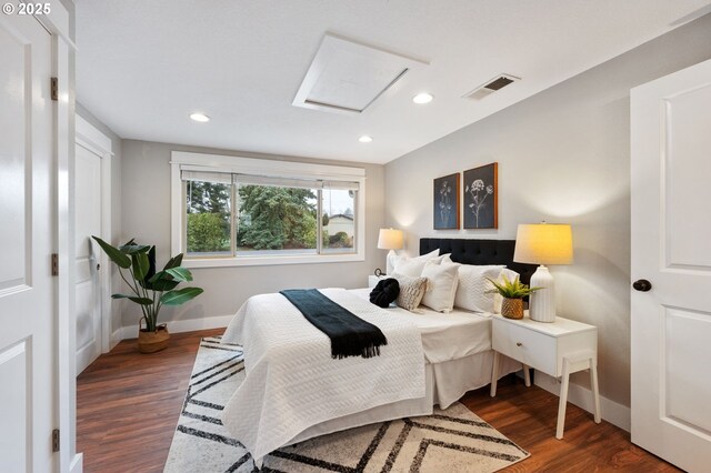 bedroom featuring connected bathroom and dark hardwood / wood-style floors